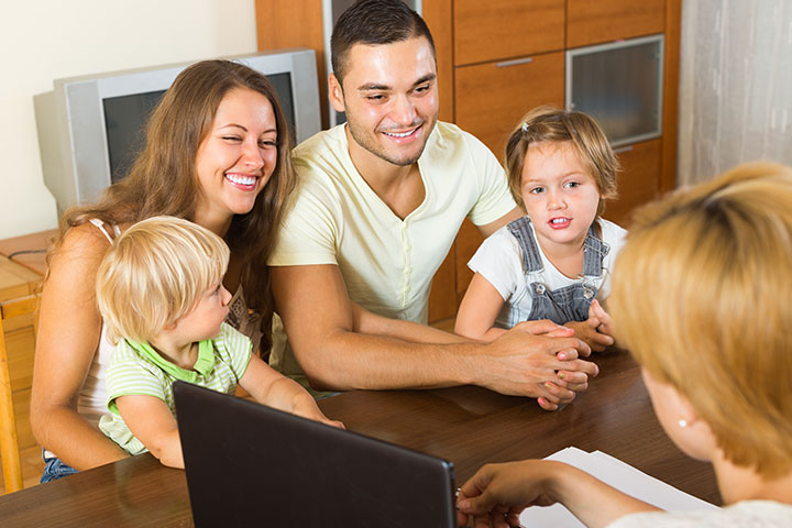 a young couple with two toddlers on lap speak to a case manager