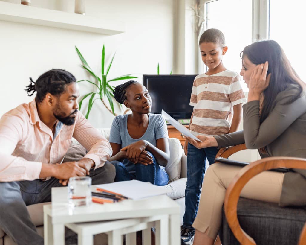 Father, mother, young boy and a female adult looking at a piece of paper